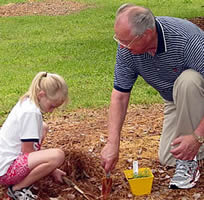 President, John Redding planting a tree with his grandaughter